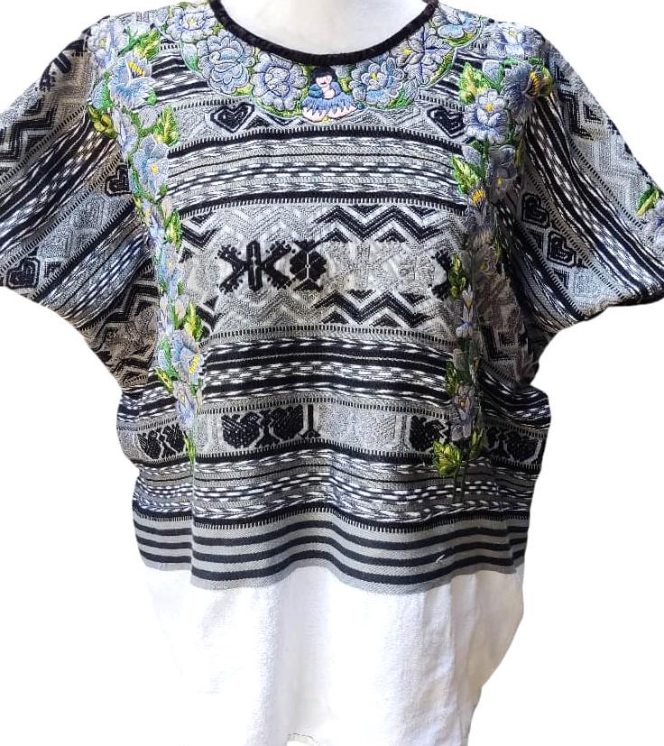 May include: A gray and black embroidered top with a white bottom. The top features intricate patterns, including floral and geometric designs. The neckline is black, and the sleeves are short. The bottom portion is a plain white fabric.